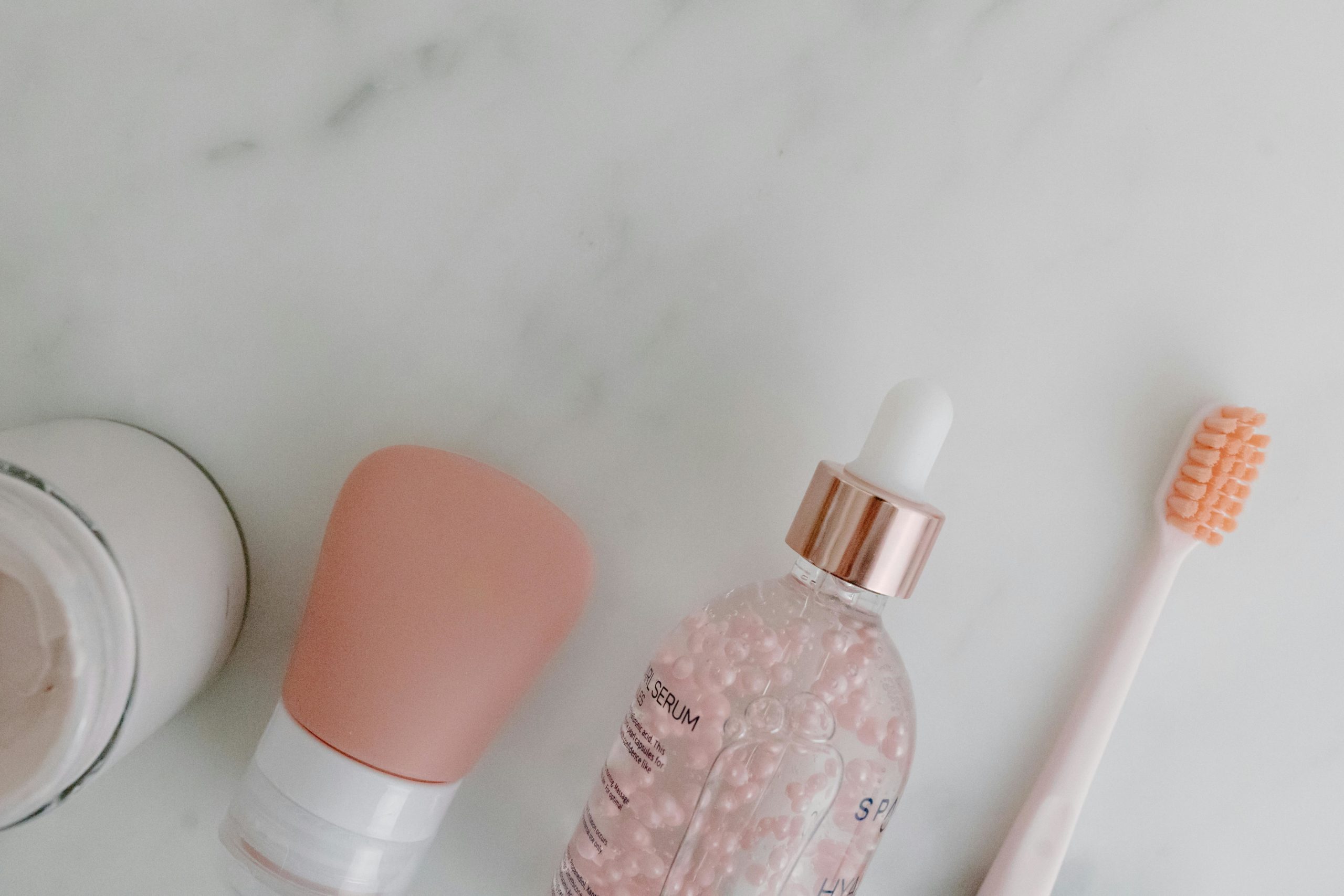 Top view of skincare products with toothbrush on marble background. Perfect for beauty and wellness themes.